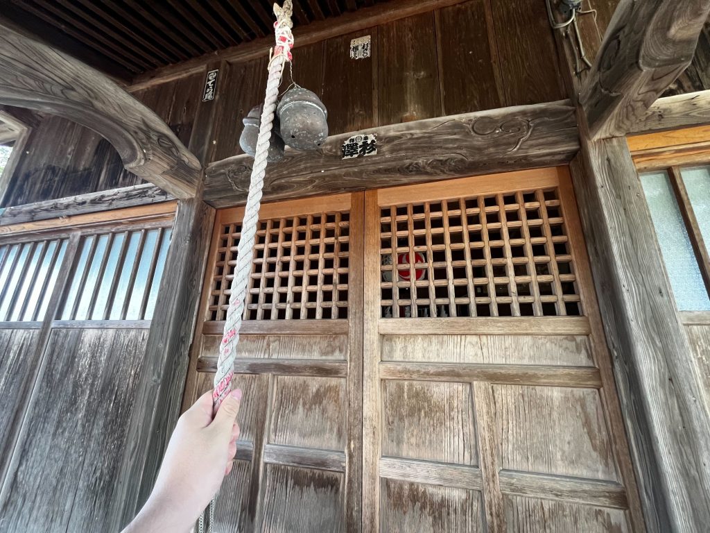 神社で鐘を鳴らす様子