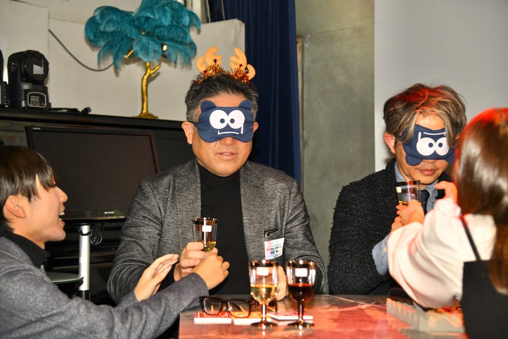 目隠しでワインを飲むチームリーダー