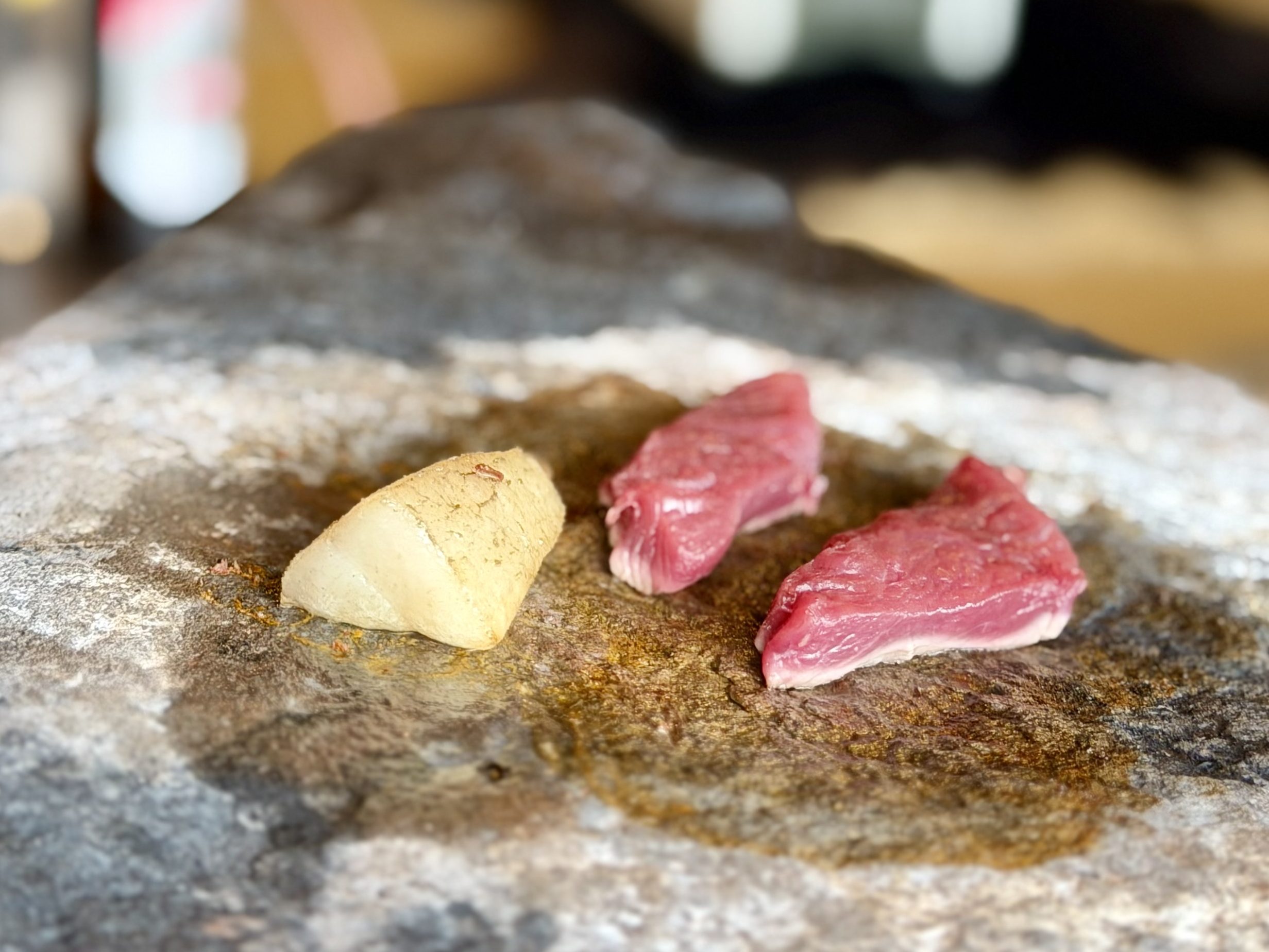 鹿肉を石器で焼いている様子