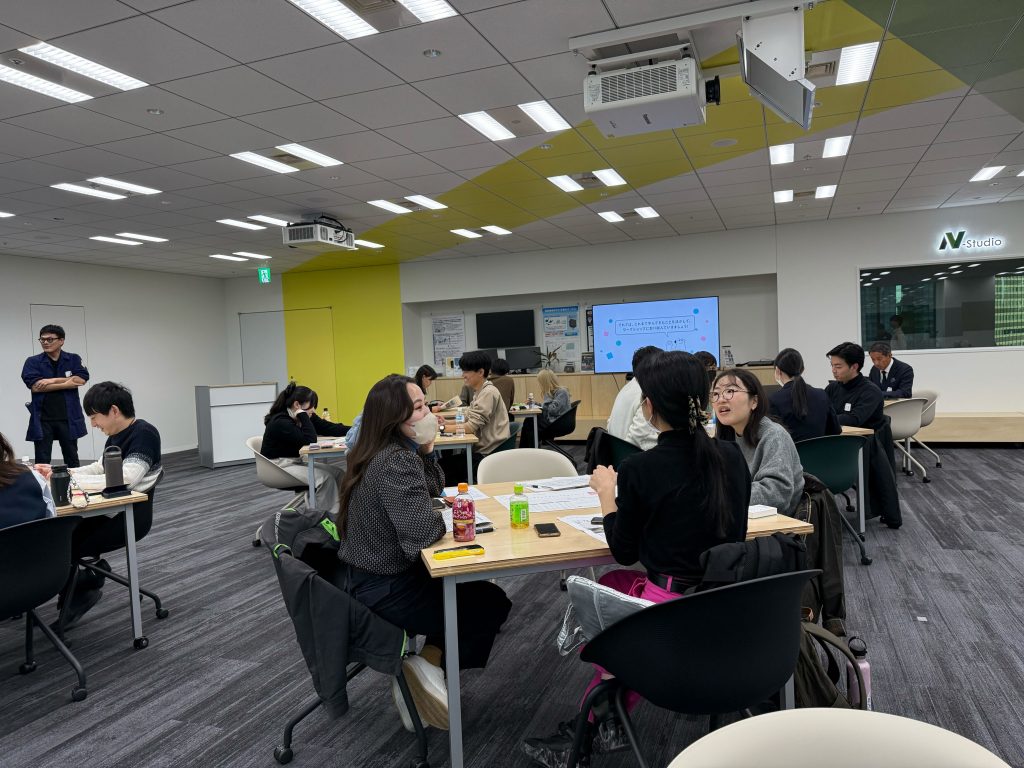 会議スペースに8島ほどのテーブルがあり、4名ずつのグループに分かれ、サステナブルアクションについて議論しています。