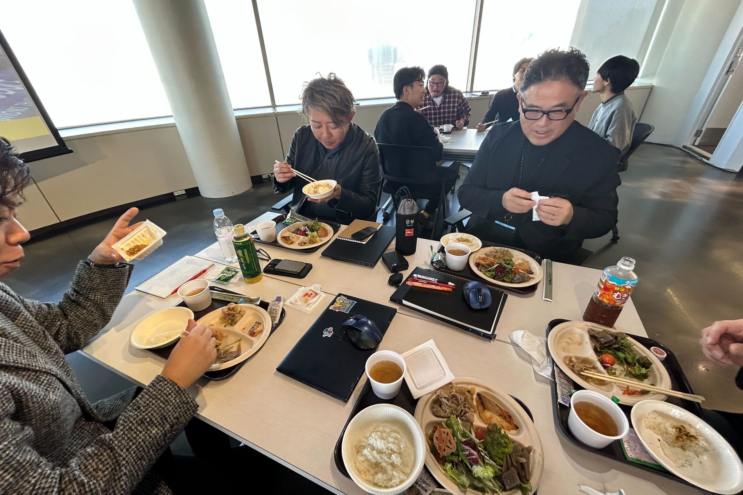 社員達がテーブルを囲んで食事する写真