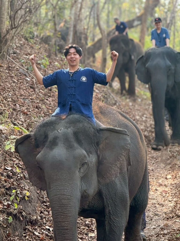 象の上でポーズを決めている様子