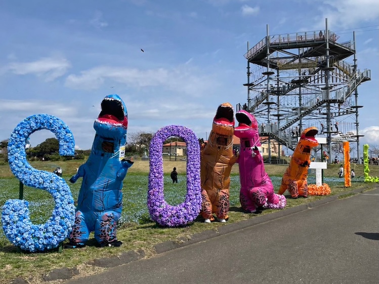 オブジェと共に写真を撮るティラノサウルス